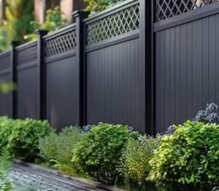 Dark powder-coated metal fence panels with lattice tops and landscaping in Apex, NC
