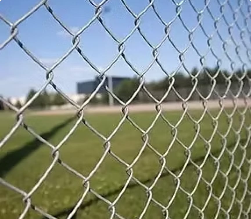 Galvanized chain link fence bordering an open field in Apex, NC