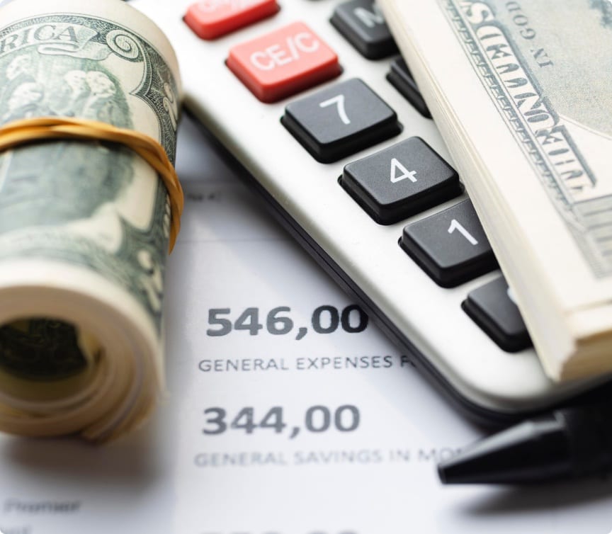 Calculator and rolled cash resting on a fence pricing worksheet